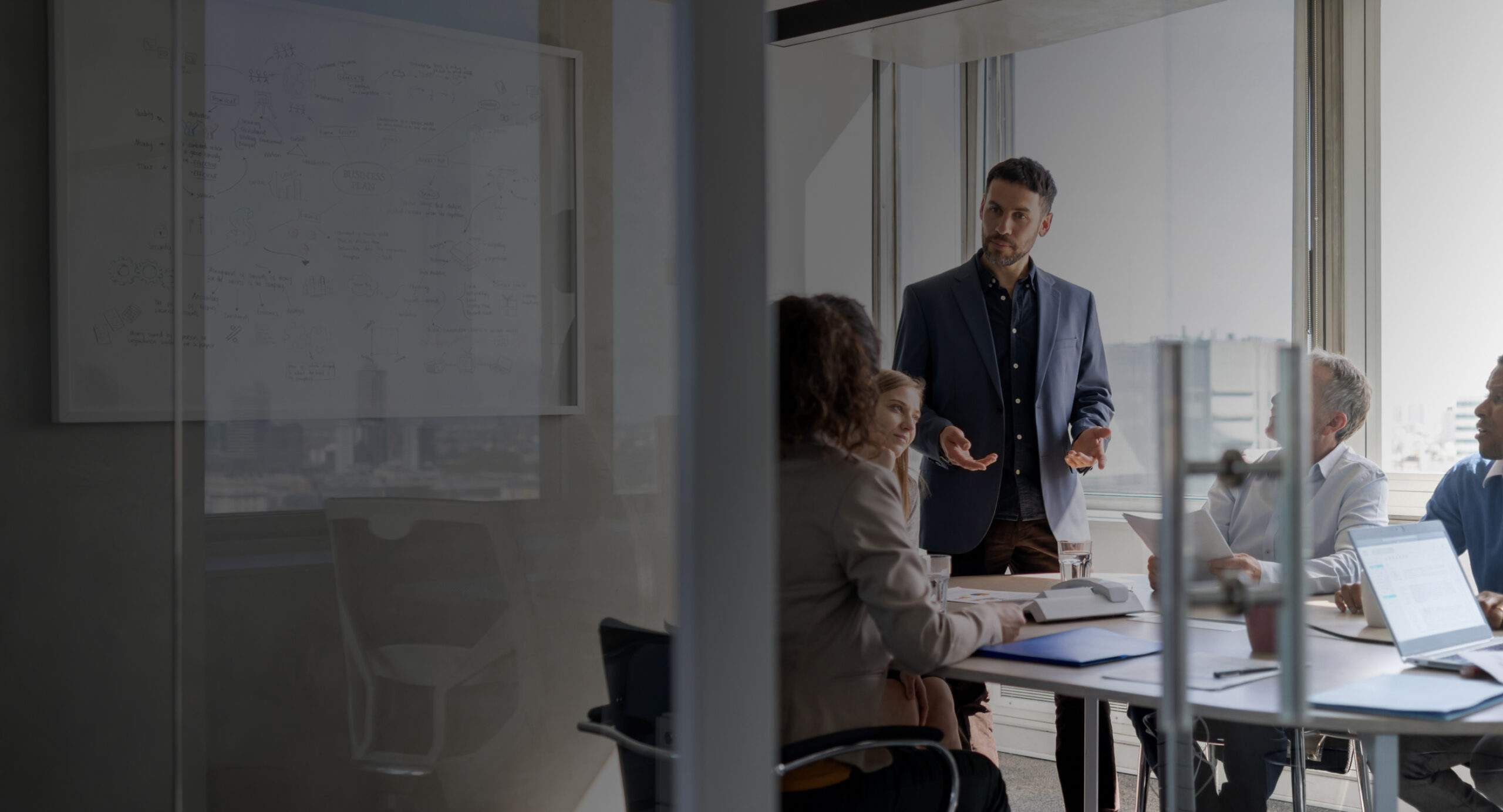 A man in a conference room speaks with his team